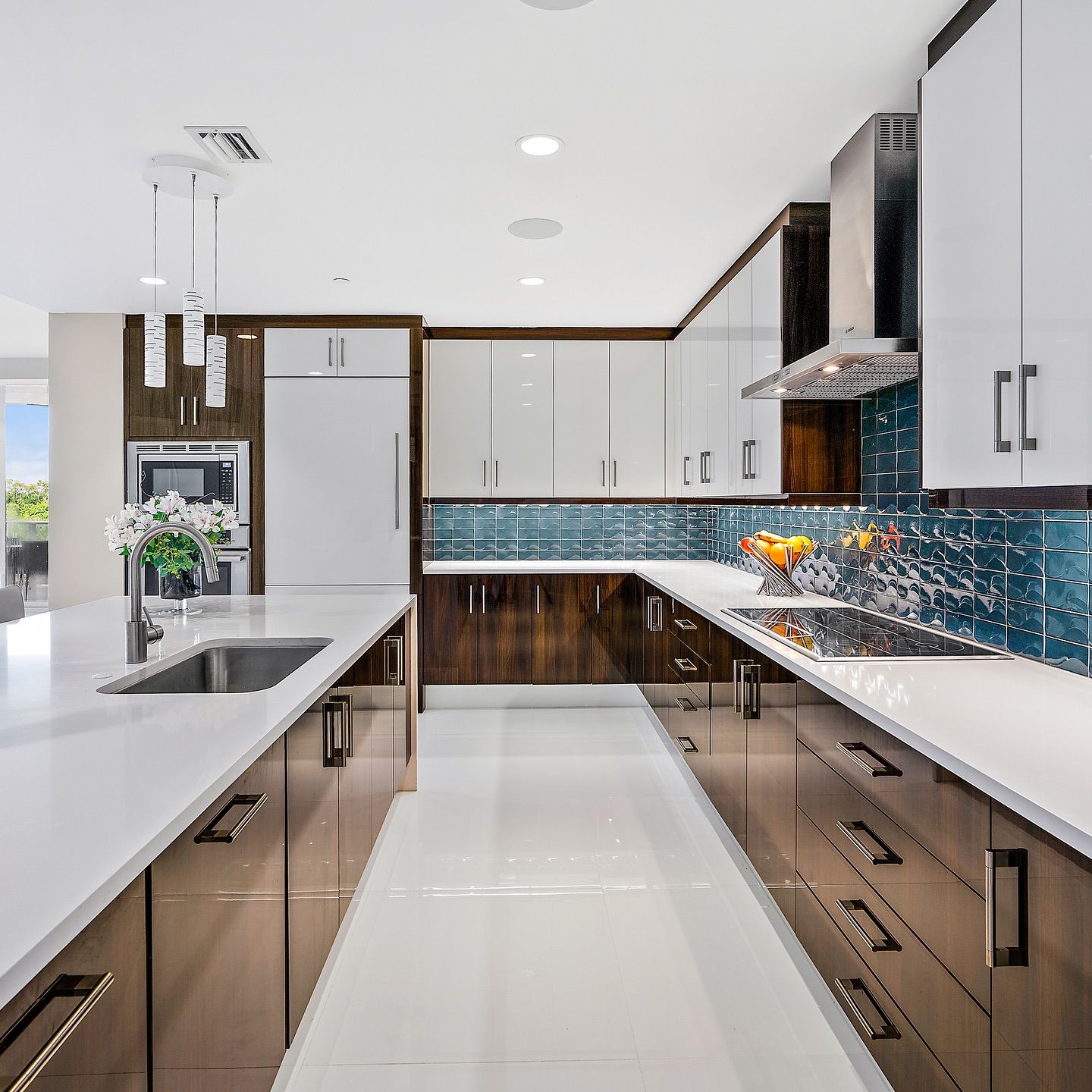 Modern kitchen with white countertops, dark wood cabinets, and blue backsplash.