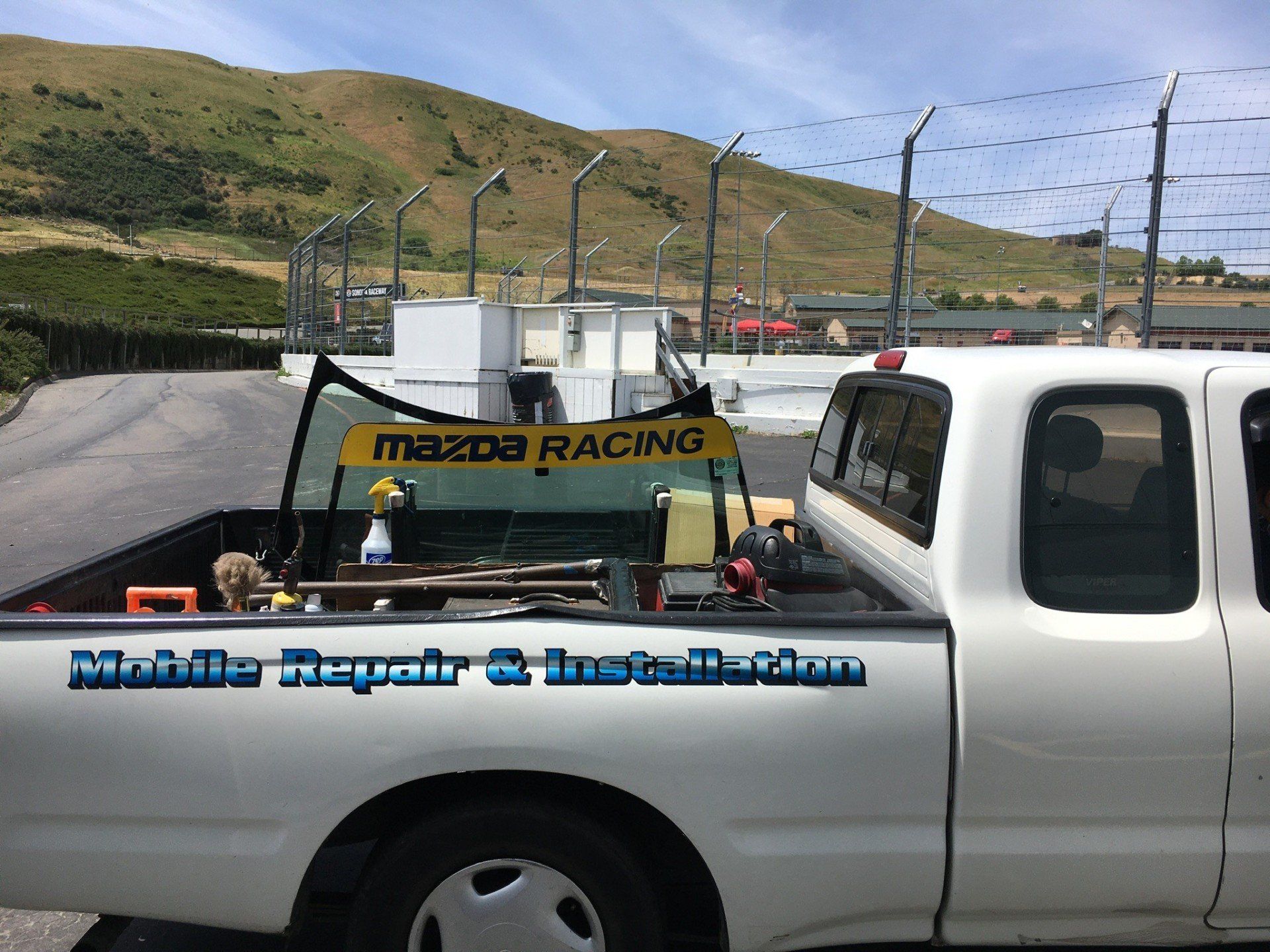 Two techs working on a windshield