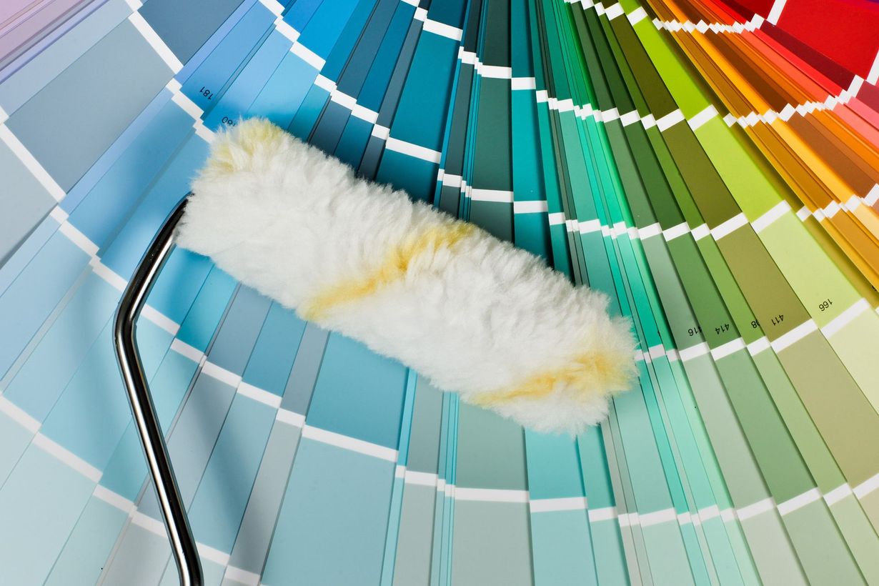 A paint roller is sitting on top of a palette of colors.