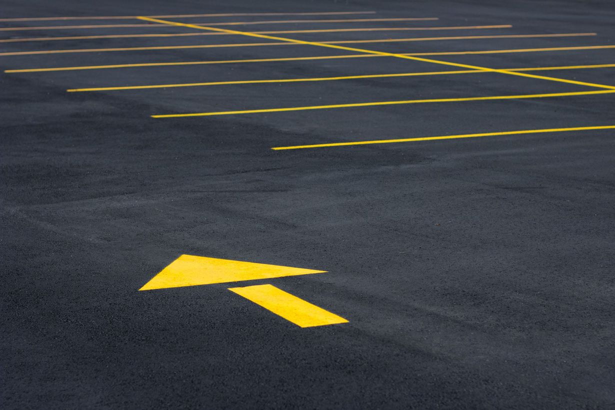 A parking lot with a yellow arrow pointing to the right