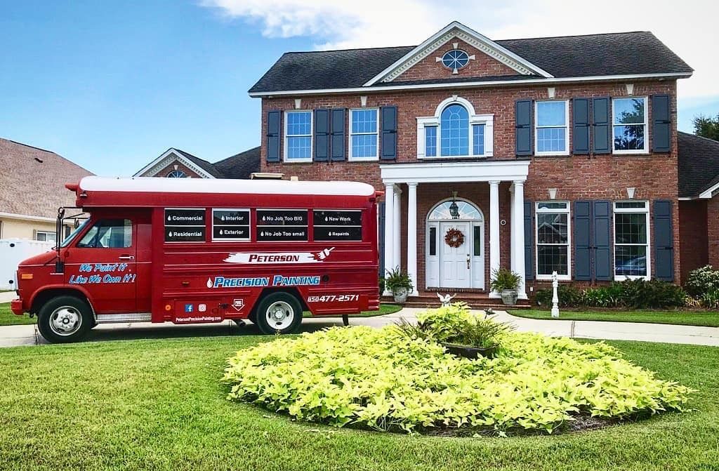 a red van is parked in front of a large brick house