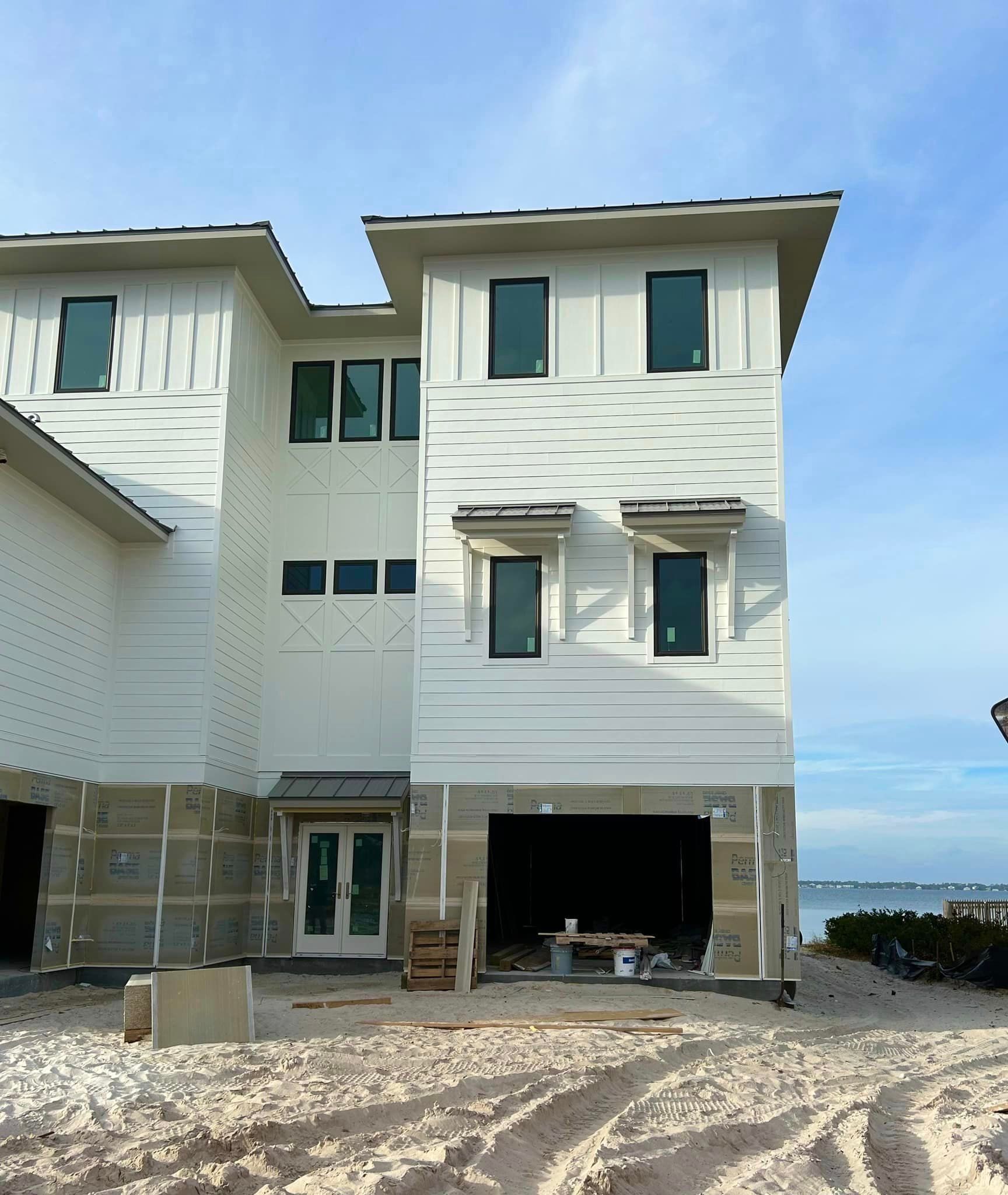 a large white house with a garage underneath it