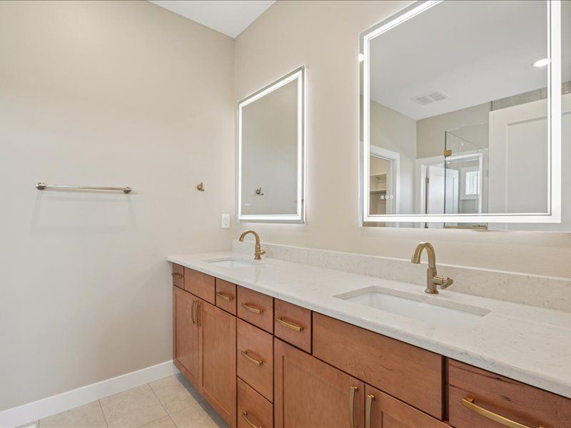 Bright modern bathroom with double vanity, large mirrors, and white countertop