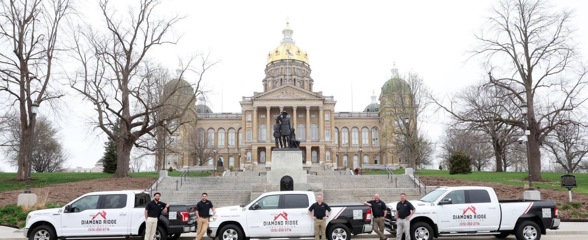 Police cars lined up in front of a large domed government building with steps and leafless trees