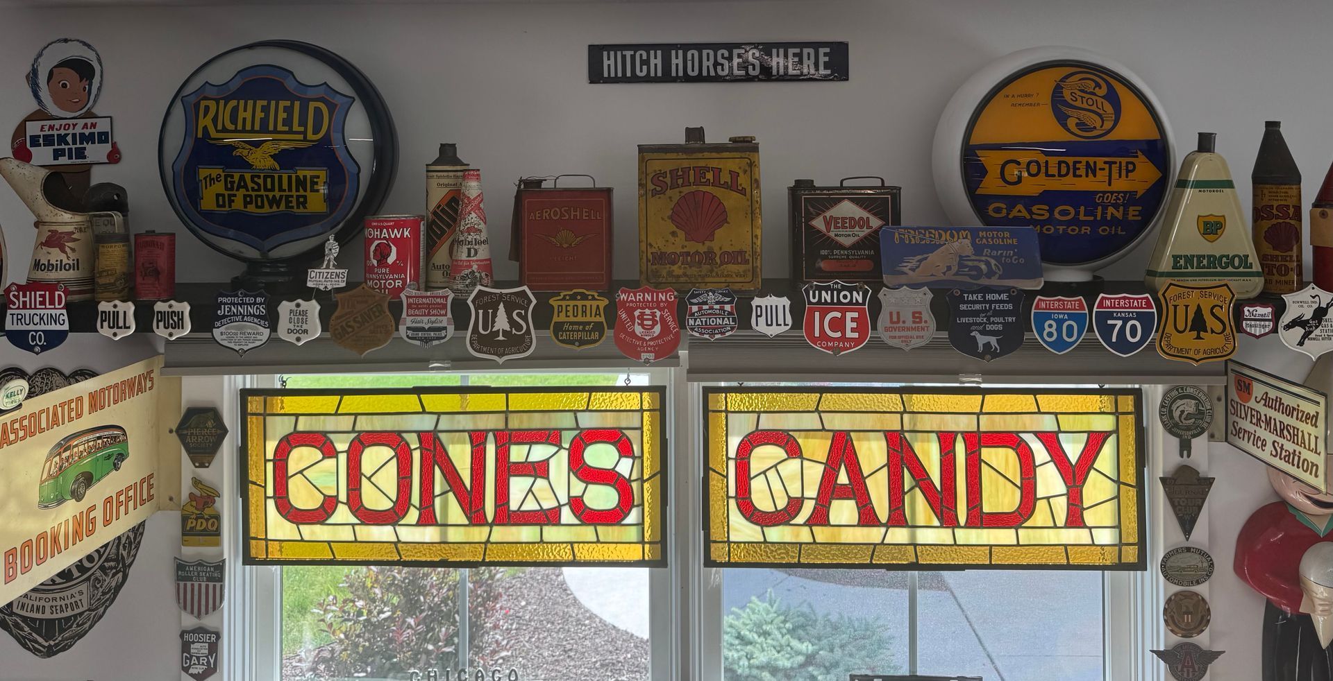 Vintage shop display with colorful signs, including large “CONES” and “CANDY” panels above the windows