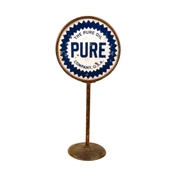 Round vintage sign on a rusted stand reading “PURE” in blue and white.