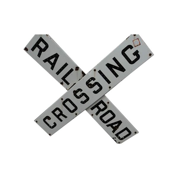 Black-and-white railroad crossing sign with crossed “RAILROAD,” “CROSSING,” and “ROAD” boards