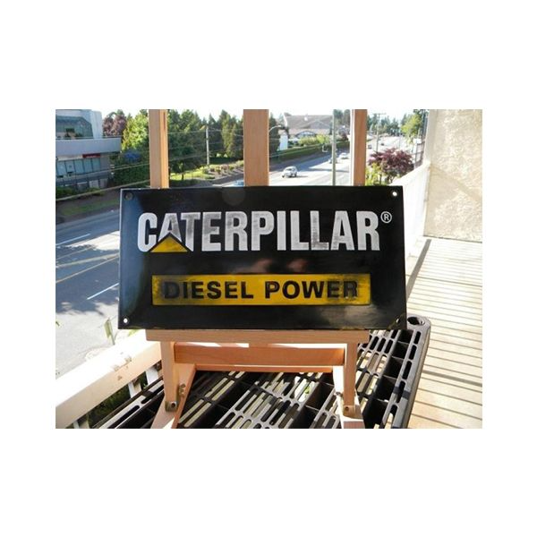Caterpillar Diesel Power sign on a balcony with trees and road in the background