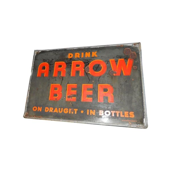 Vintage metal sign reading “DRINK ARROW BEER” in red letters on a dark background.