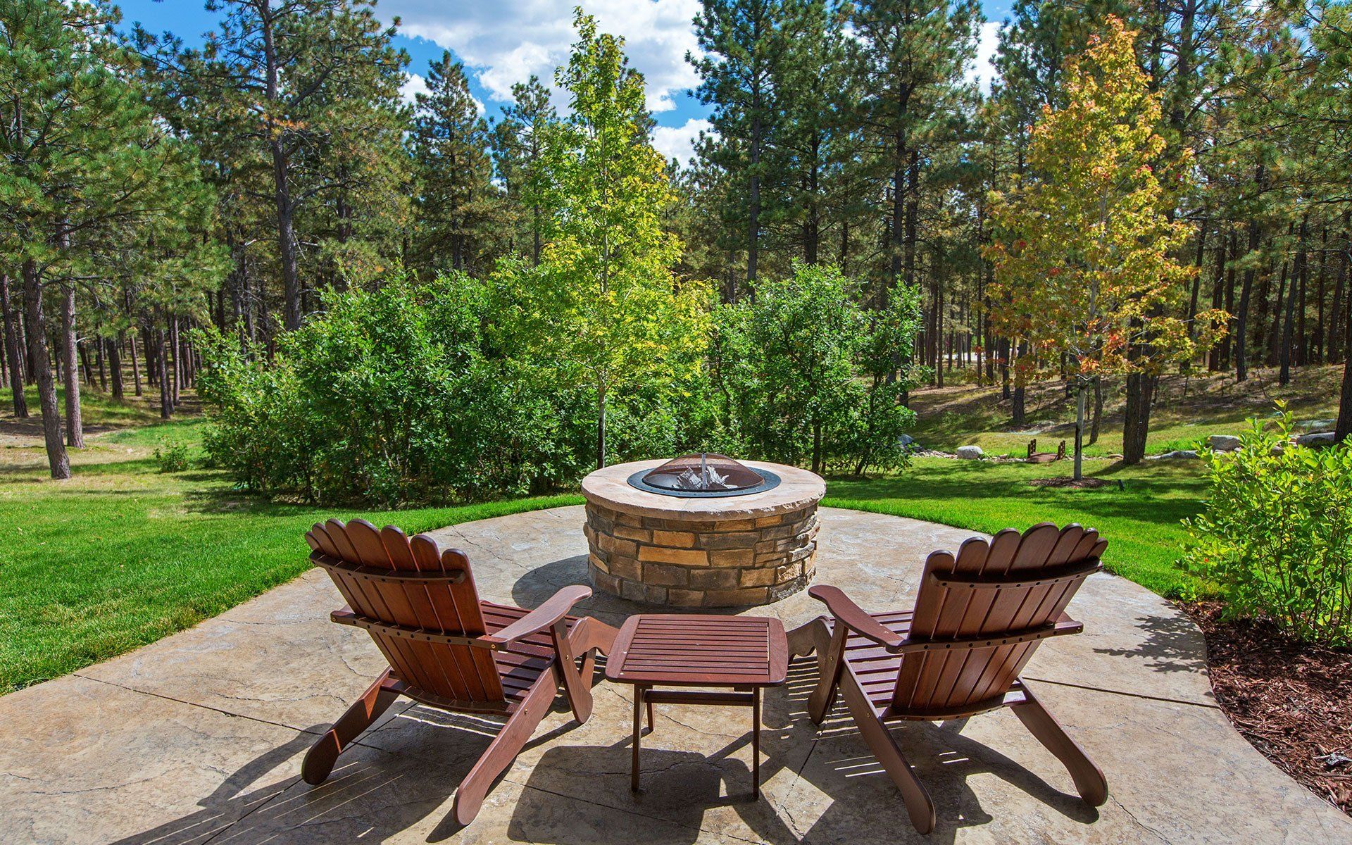 A view of outside garden with chairs and firepit