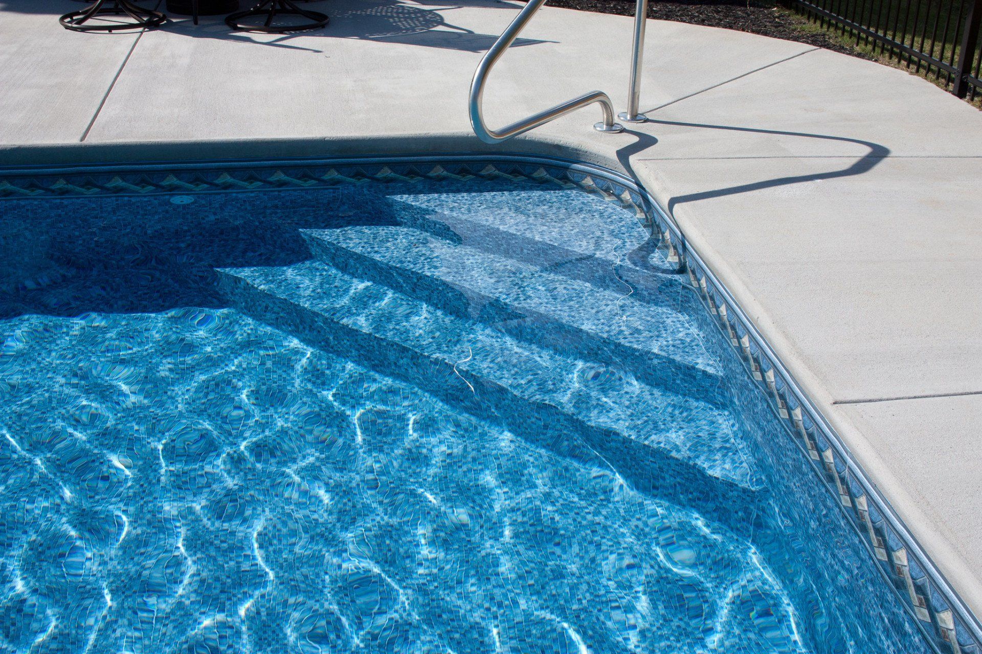 Swimming pool with handle bar and stairs underneath