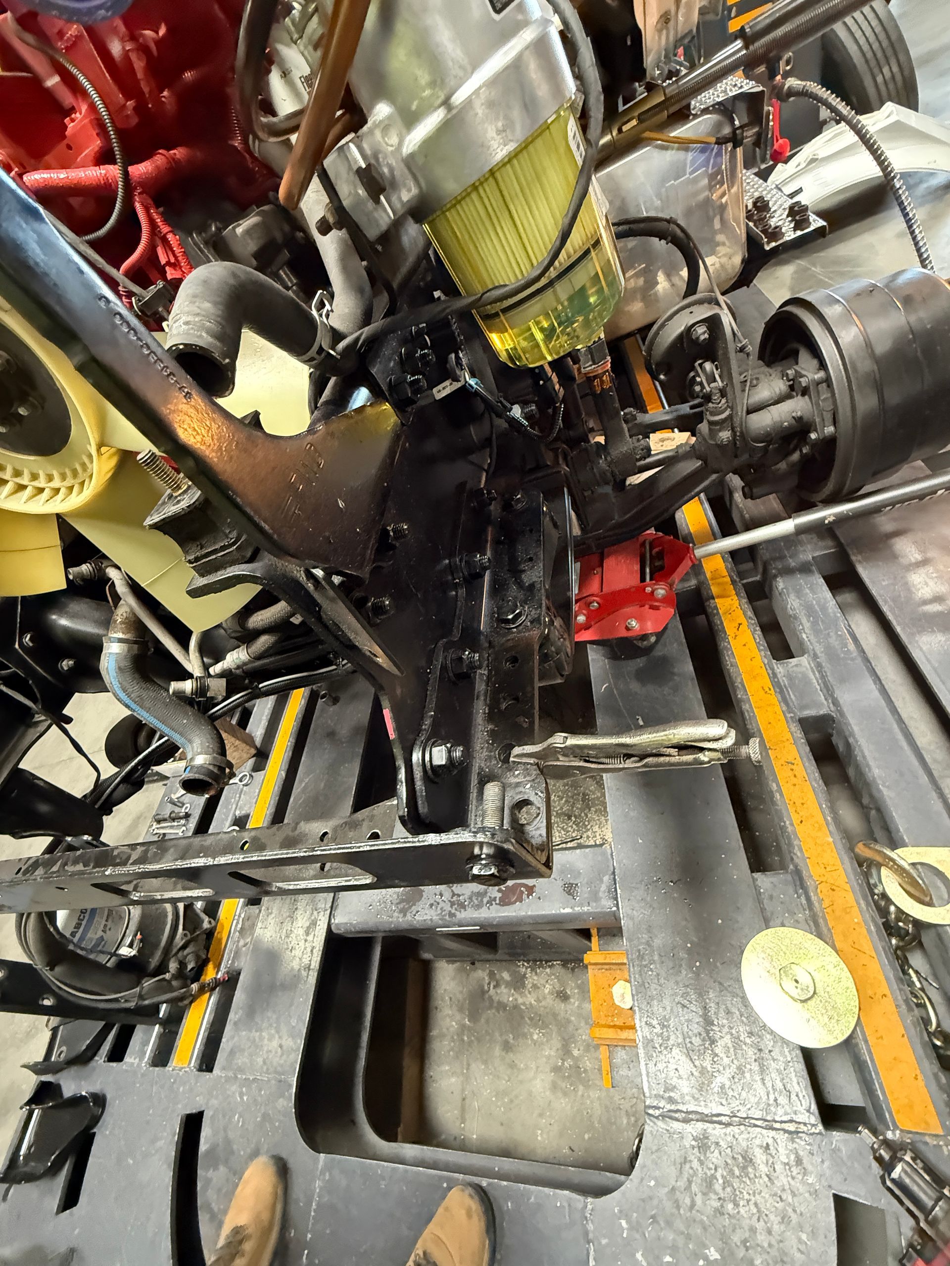 A close-up view of the interior engine compartment of a large vehicle, showing a yellow fuel filter and mechanical parts.