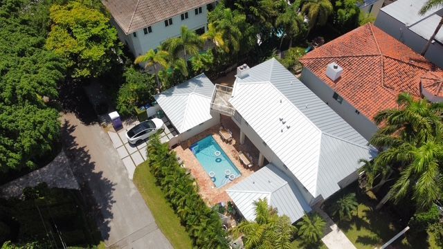 An aerial view of a house with a pool in the backyard.