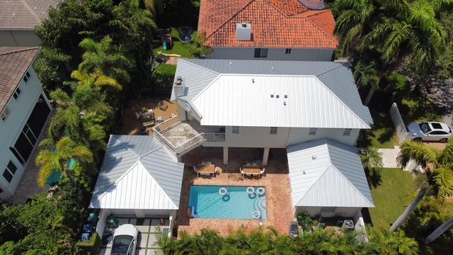 An aerial view of a house with a pool and a car parked in front of it.