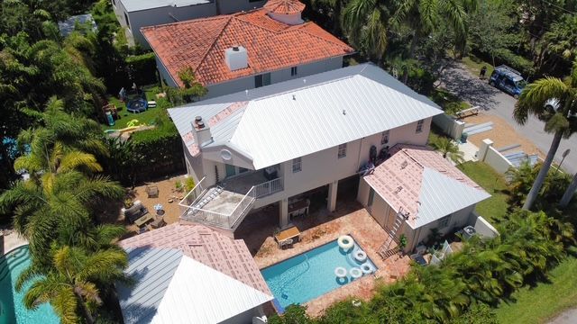 An aerial view of a house with a pool in the backyard.