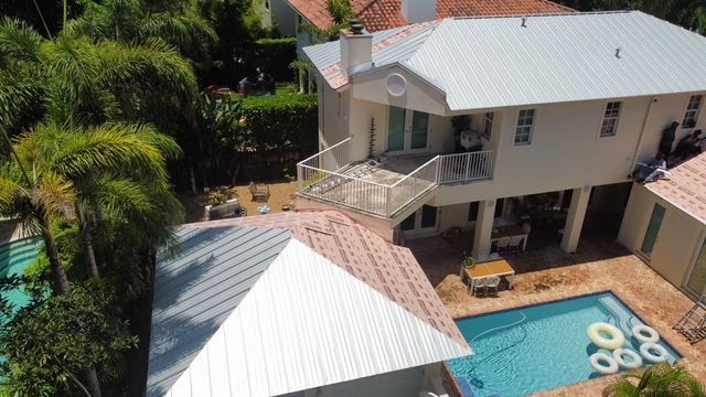 An aerial view of a house with a swimming pool in the backyard.