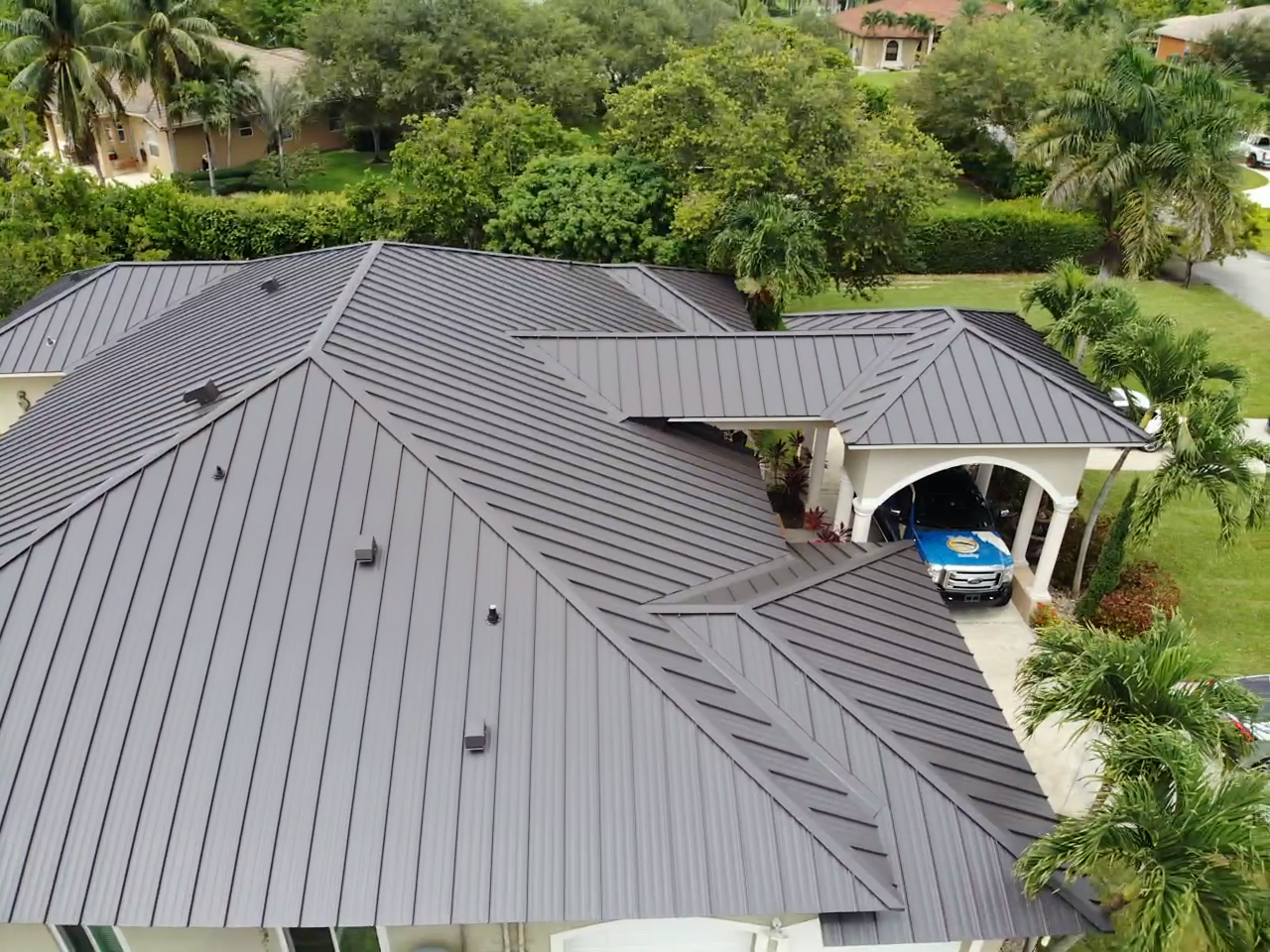 An aerial view of a large house with a metal roof.