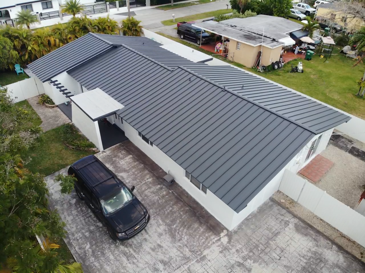 An aerial view of a house with a black car parked in front of it.
