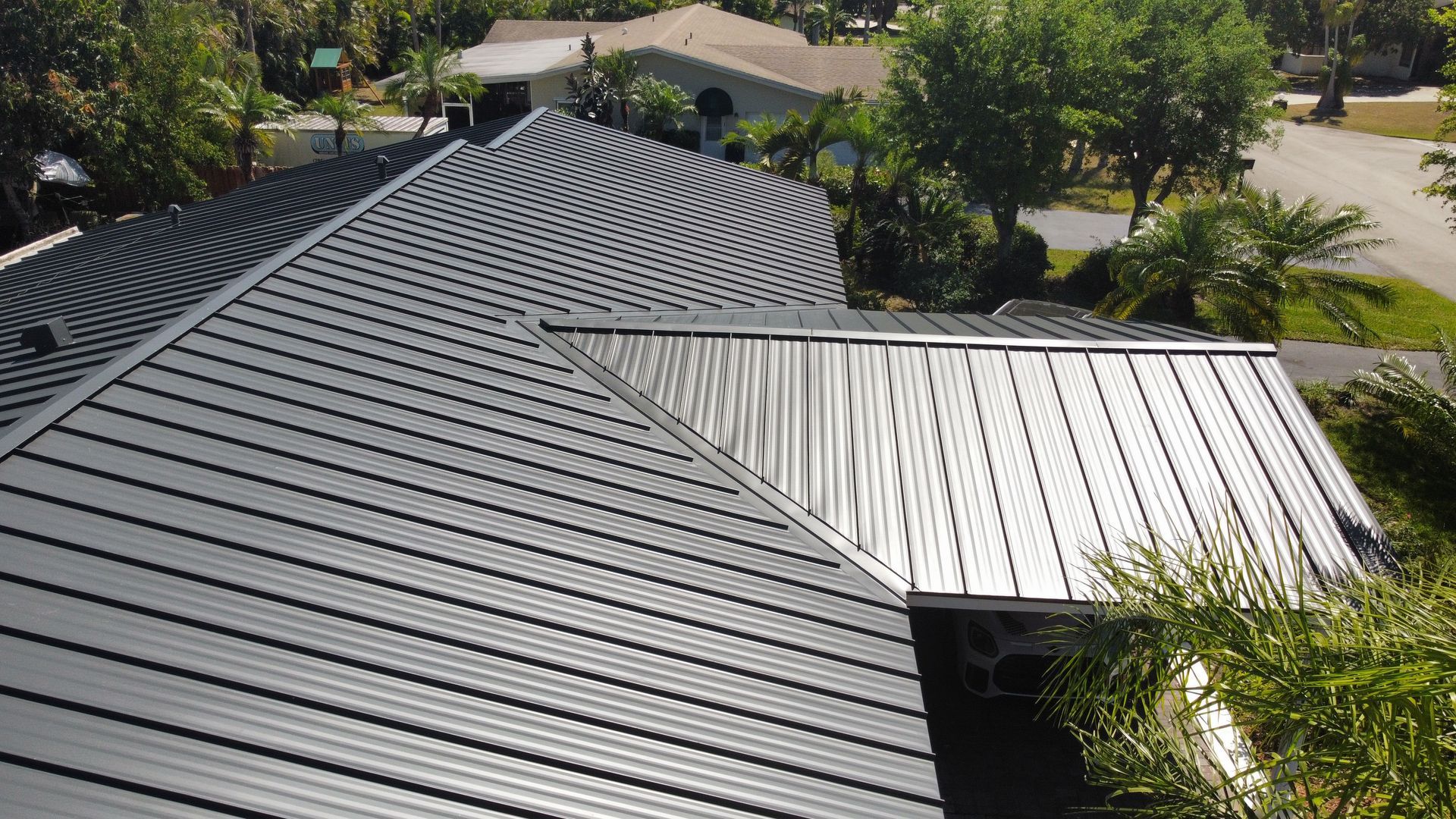An aerial view of a house with a black metal roof.