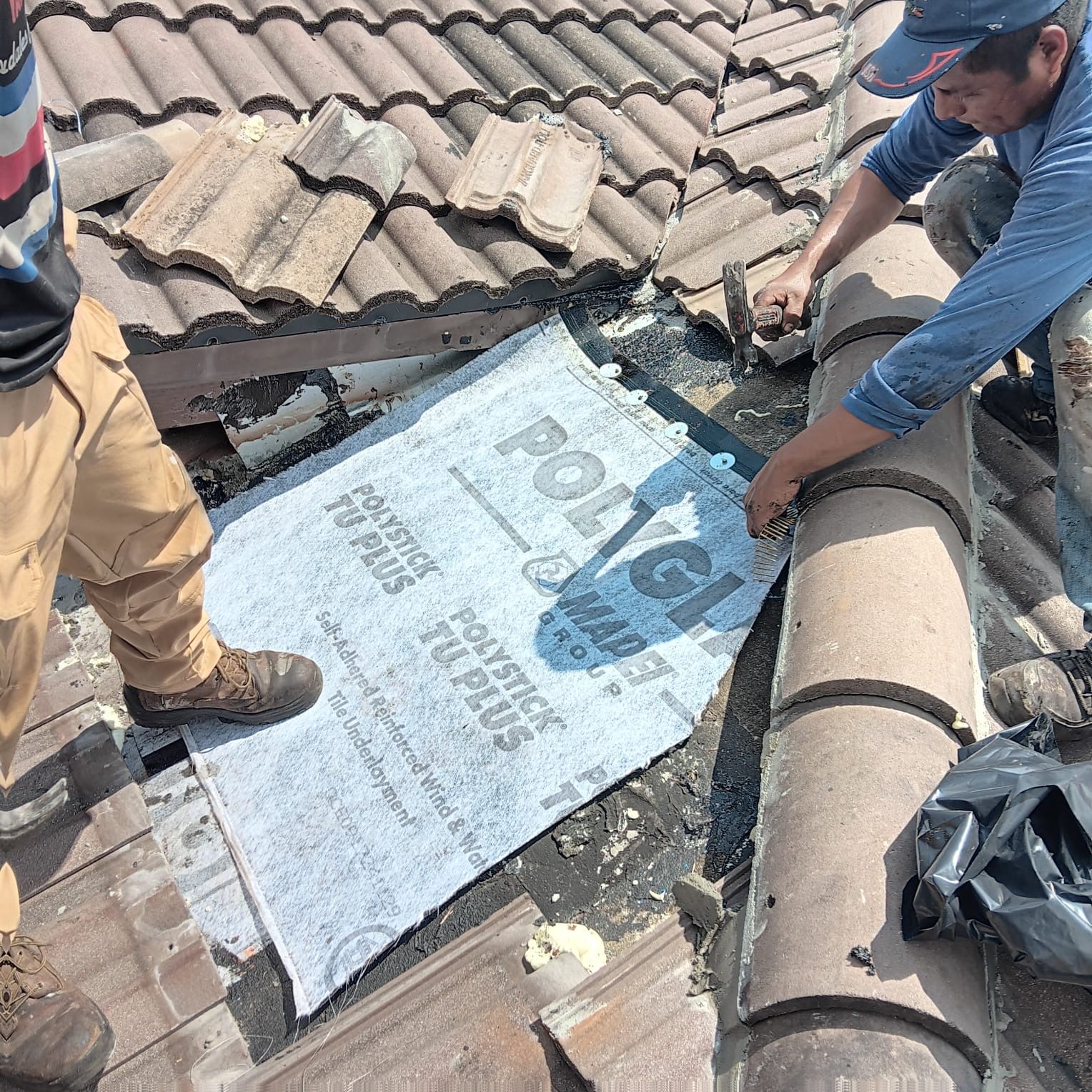 A man is working on the roof of a house.