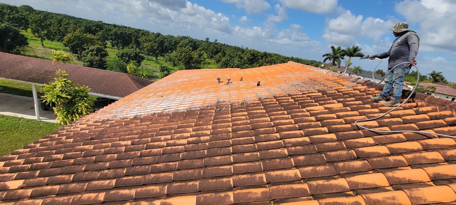 A man is standing on top of a tiled roof.