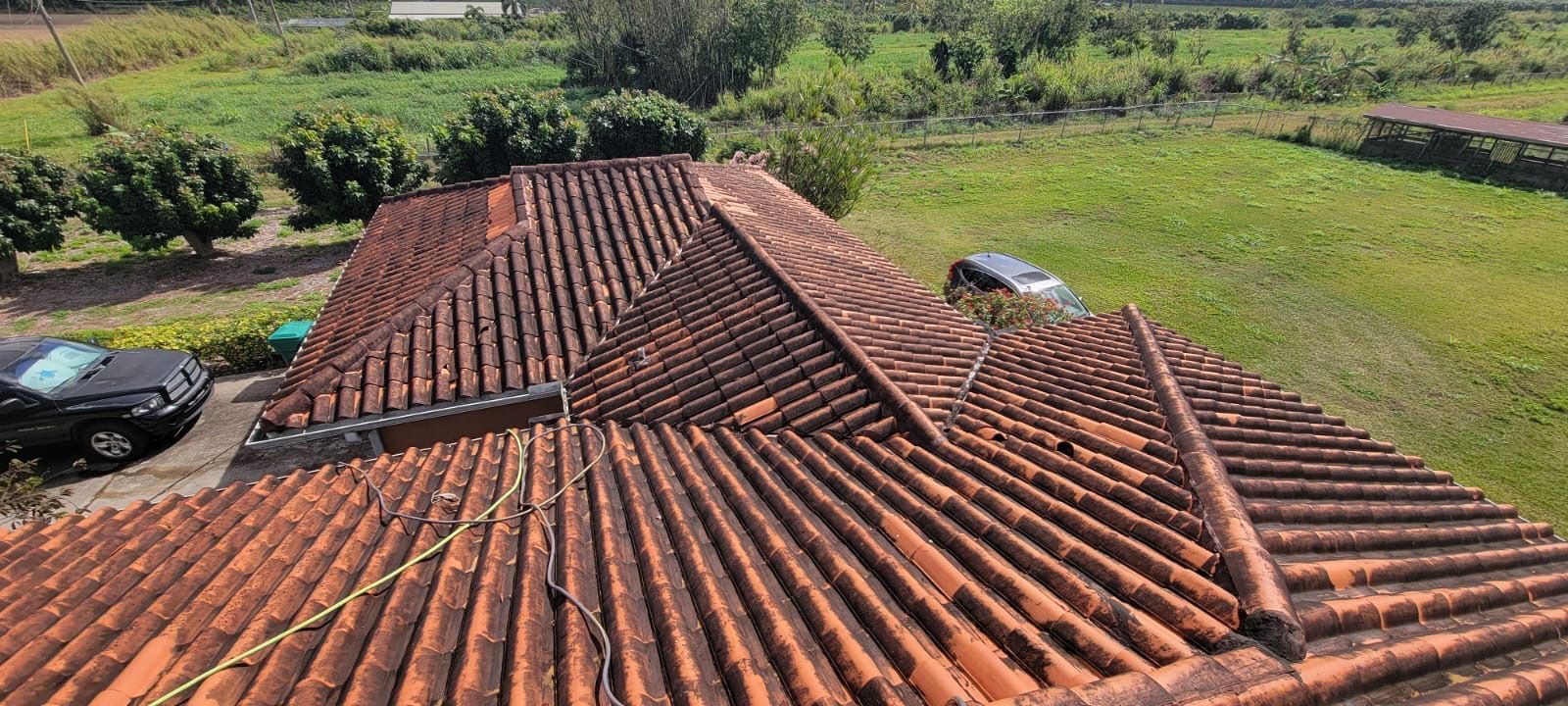 An aerial view of a tiled roof with a car parked in front of it.