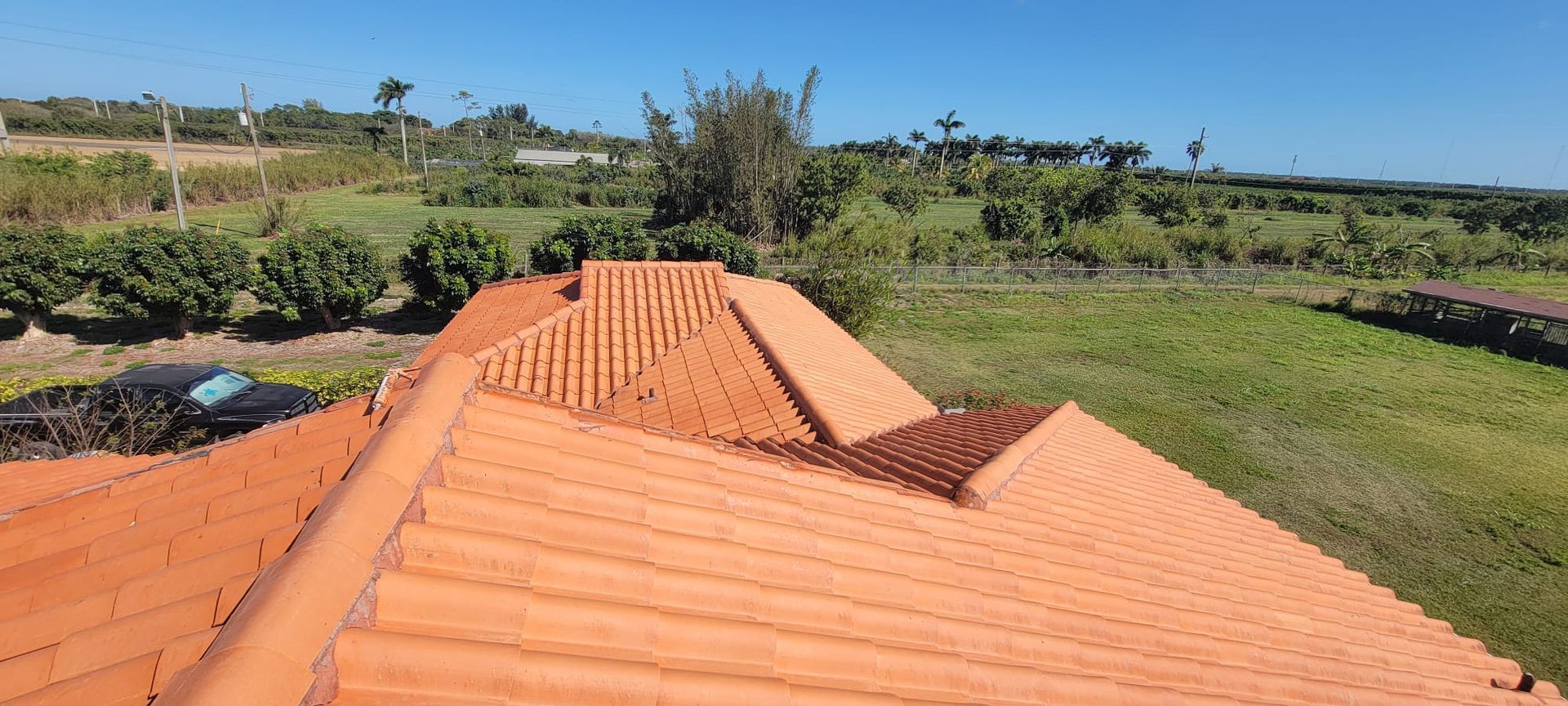 An aerial view of a roof with a car parked on the side of it.