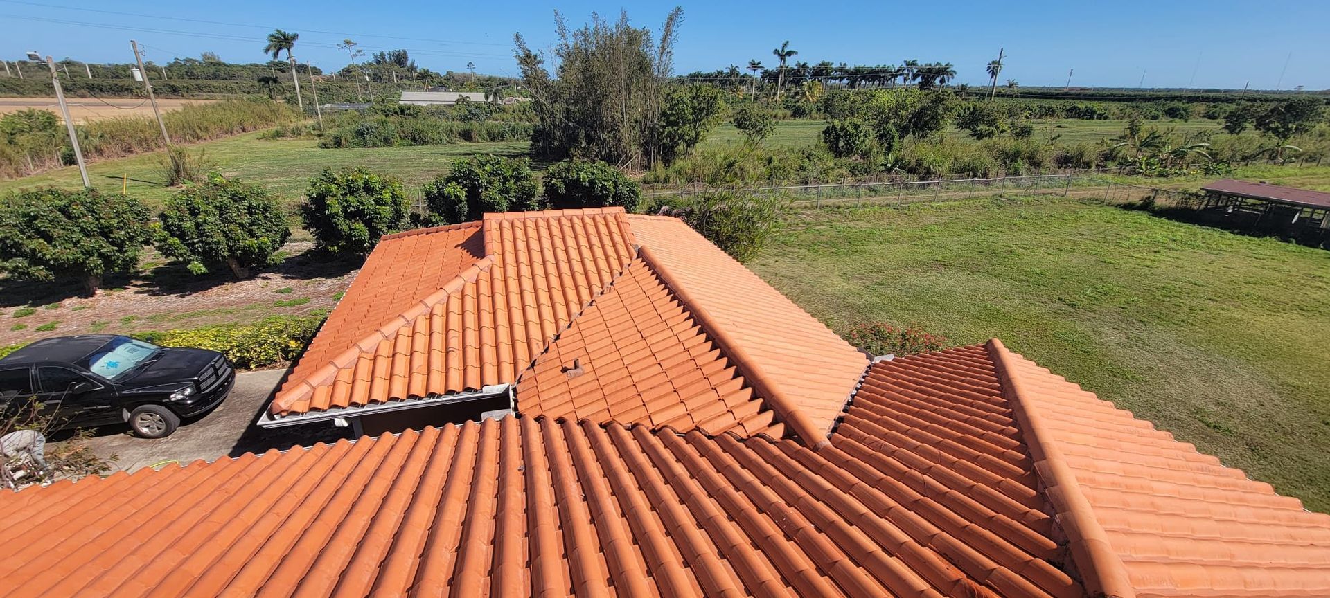 An aerial view of a roof of a house with a car parked in front of it.