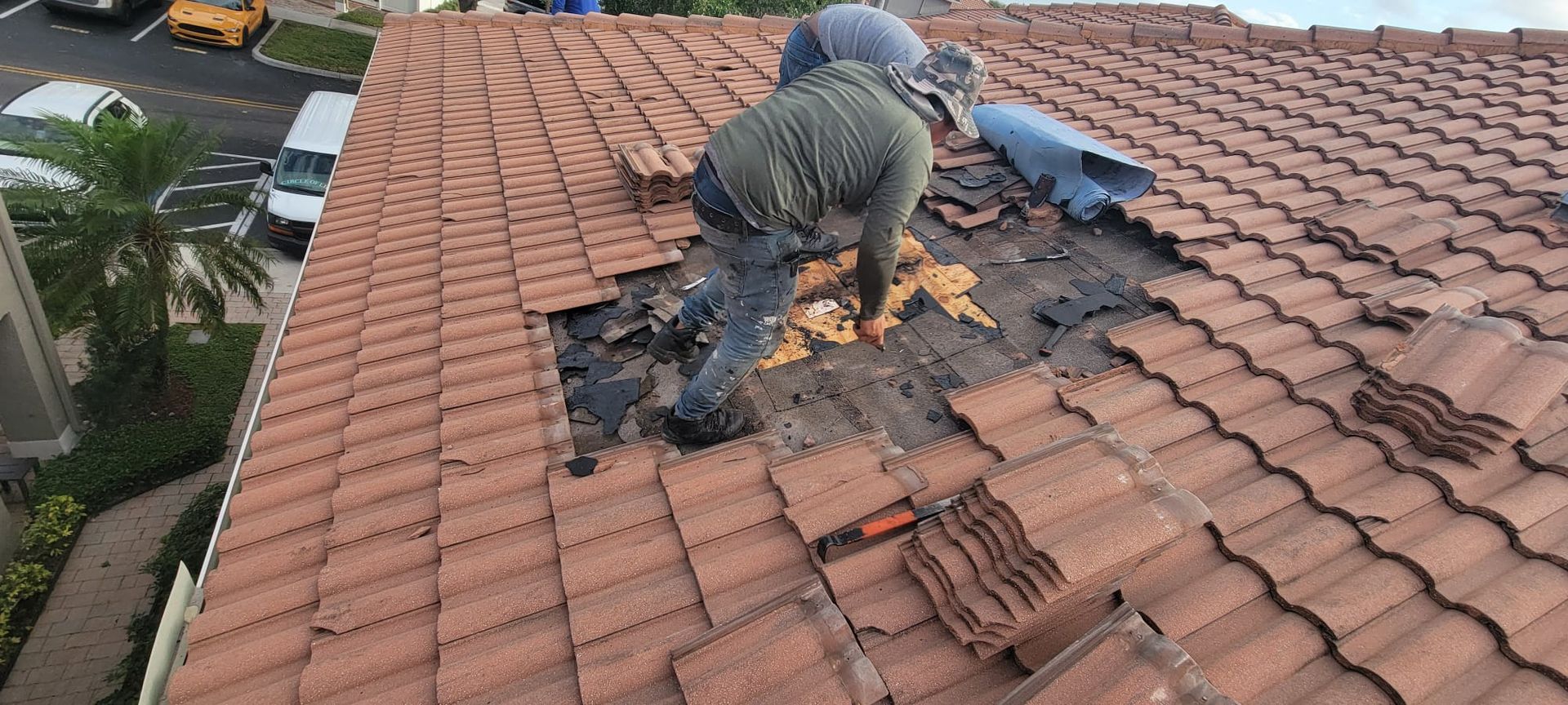 A man is working on the roof of a house.