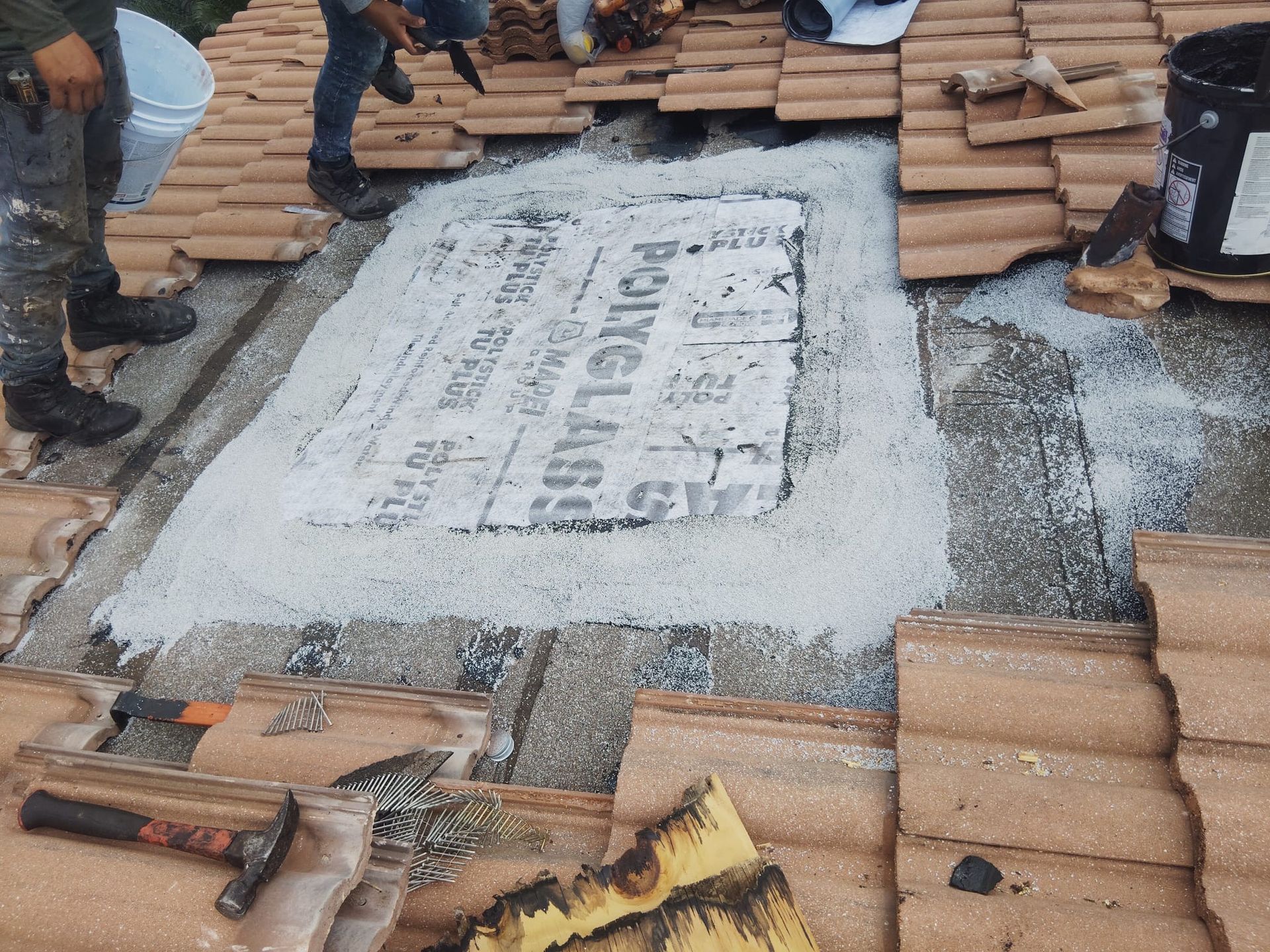 A group of people are working on a tiled roof.