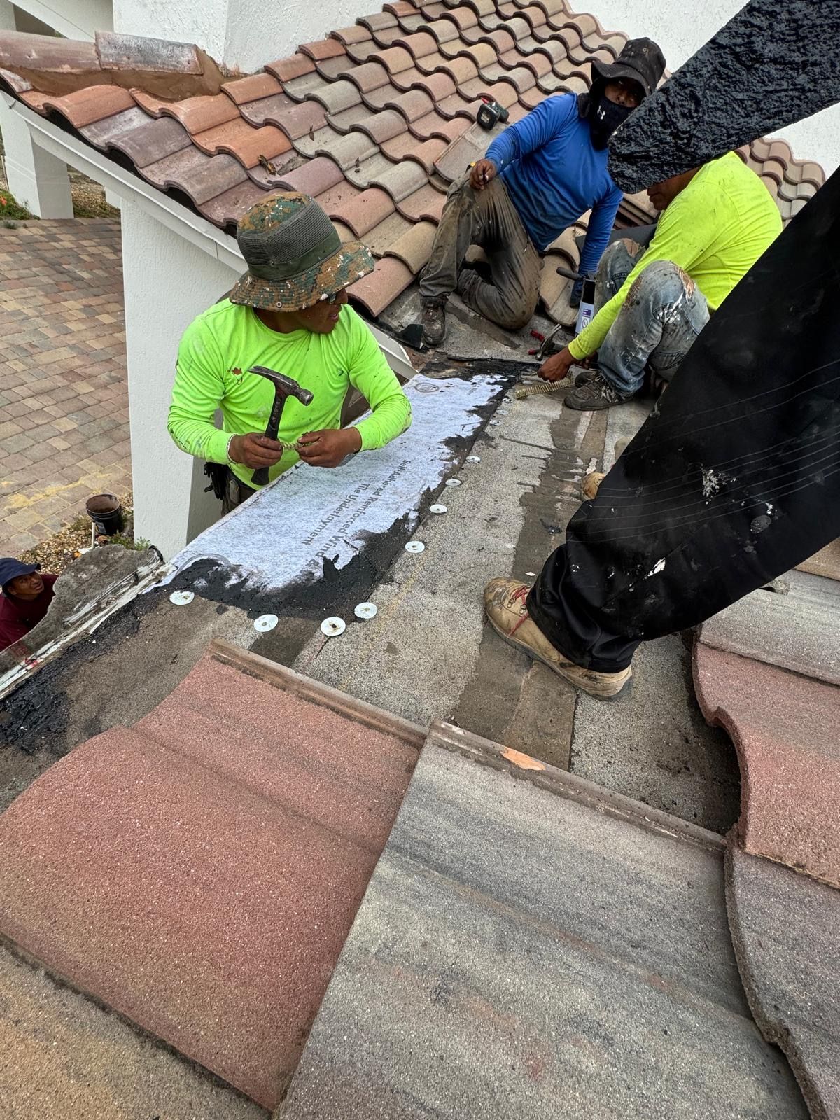 A group of men are working on a roof.