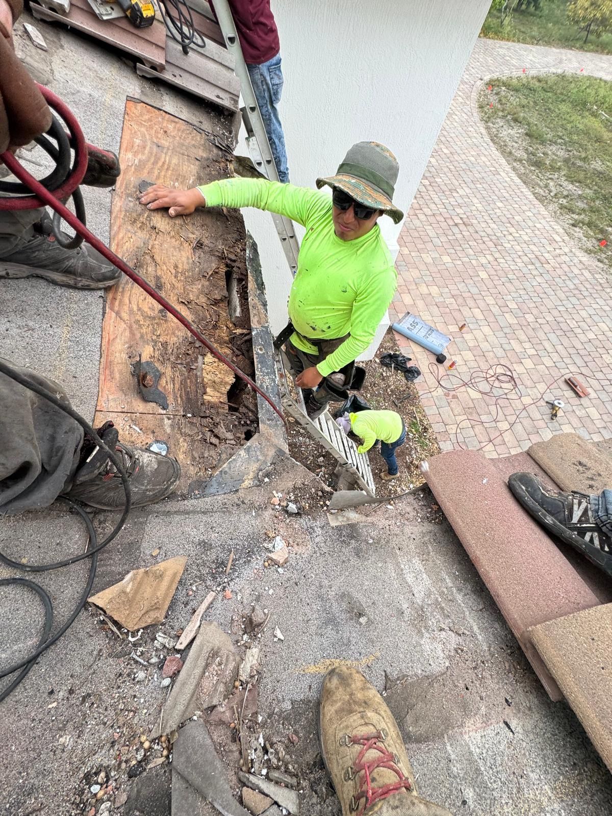 A man in a neon green shirt is working on a building.