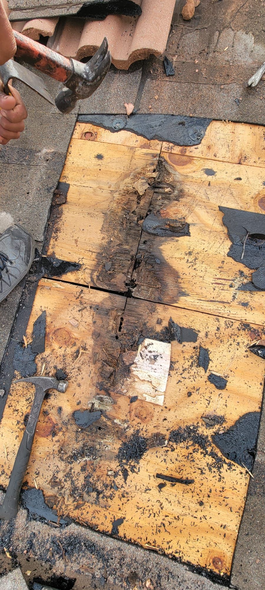 A person is hammering a piece of wood with a hammer.