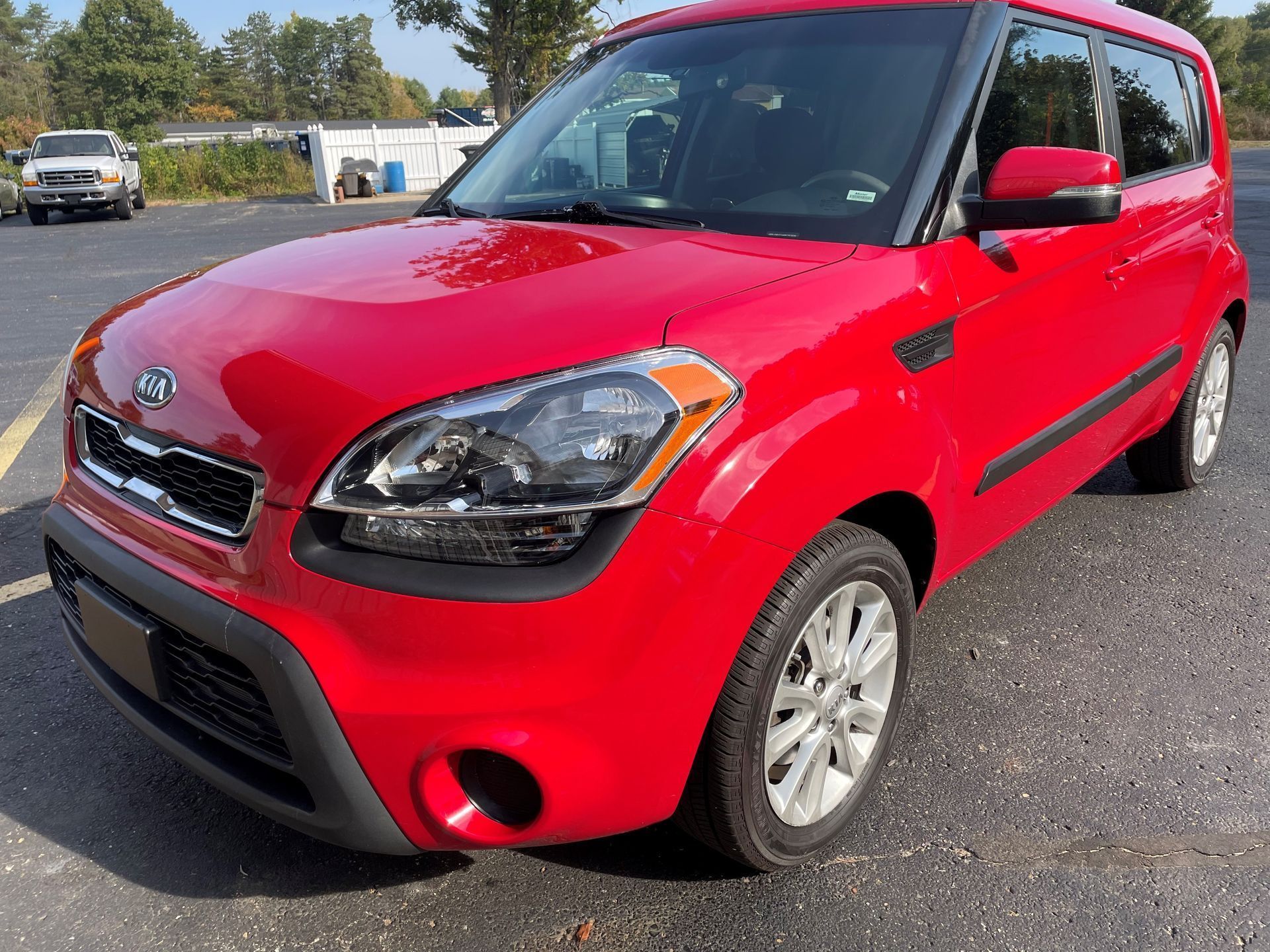 Red Kia Soul parked outside on a sunny day.