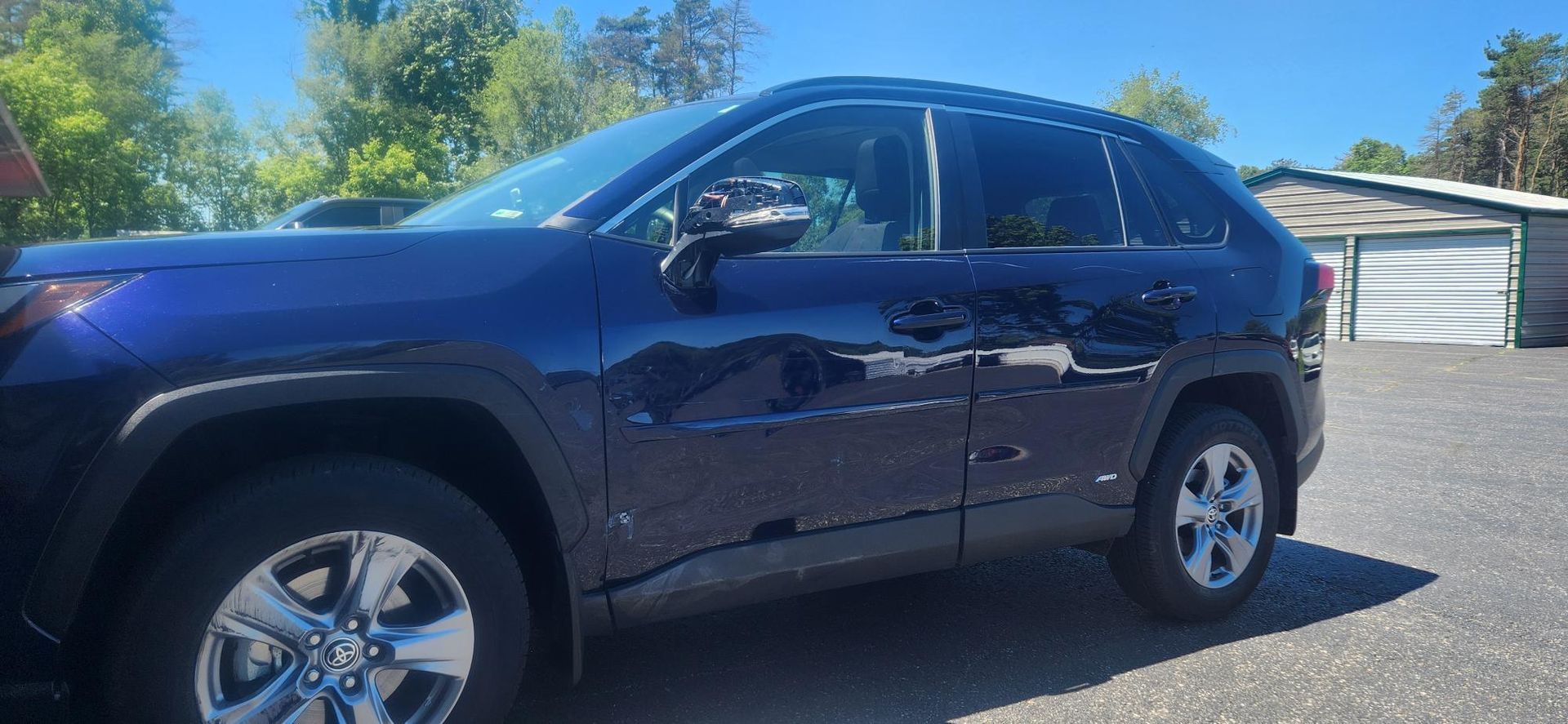 Blue Toyota RAV4 SUV parked outside, sunny day.
