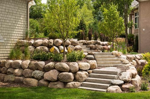 a stone wall with stairs leading up to a house .