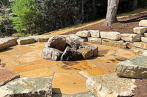 a fire pit is surrounded by rocks on a patio .