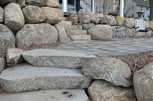 a pile of rocks sitting on top of a patio next to a house .