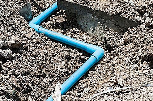 a blue pipe is laying in the dirt .