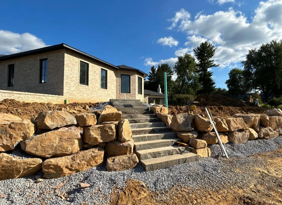 a house with stairs leading up to it is surrounded by rocks