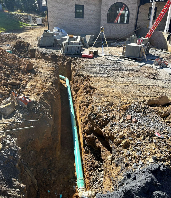 a green pipe is coming out of a hole in the ground