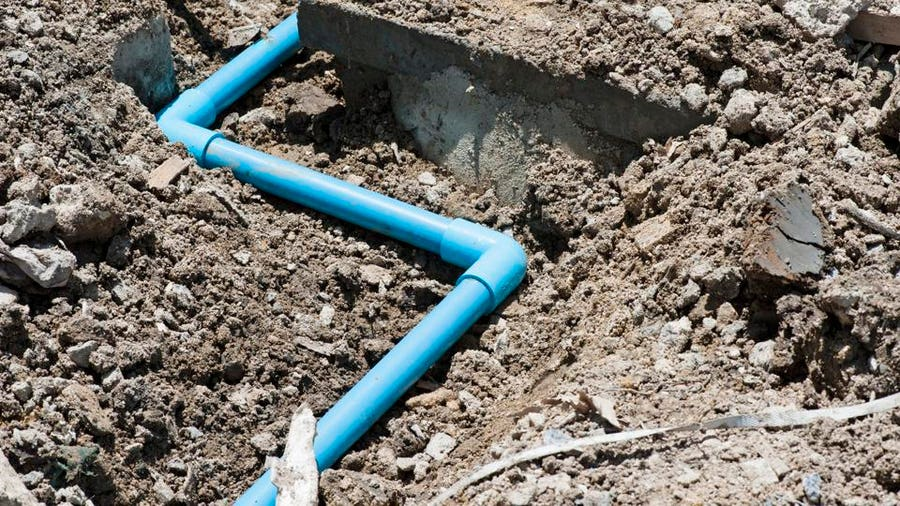 a blue pipe is laying in the dirt