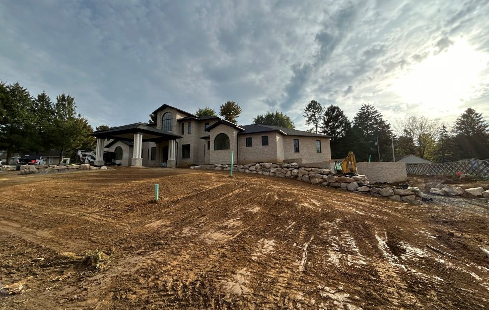 a large house is being built in the middle of a dirt field