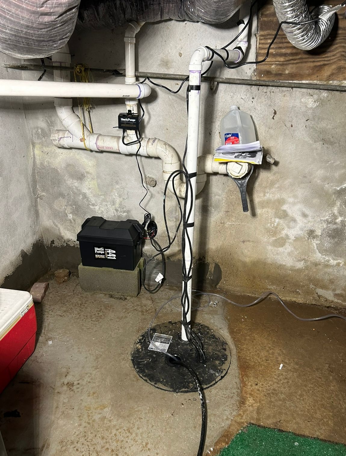a sump pump is sitting in a basement next to a cooler