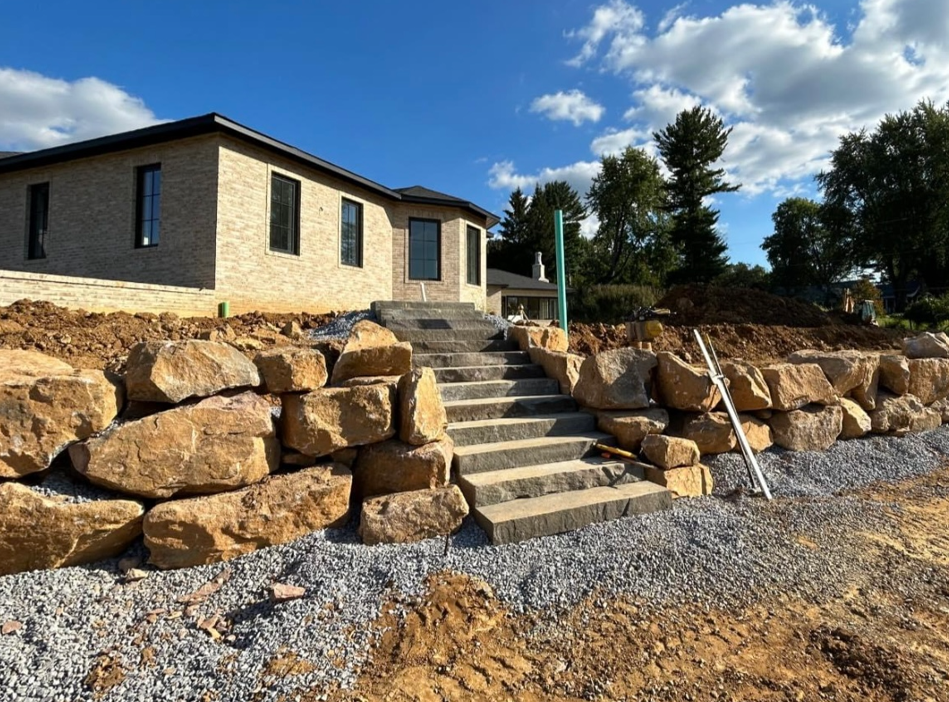 a house with stairs leading up to it is surrounded by rocks