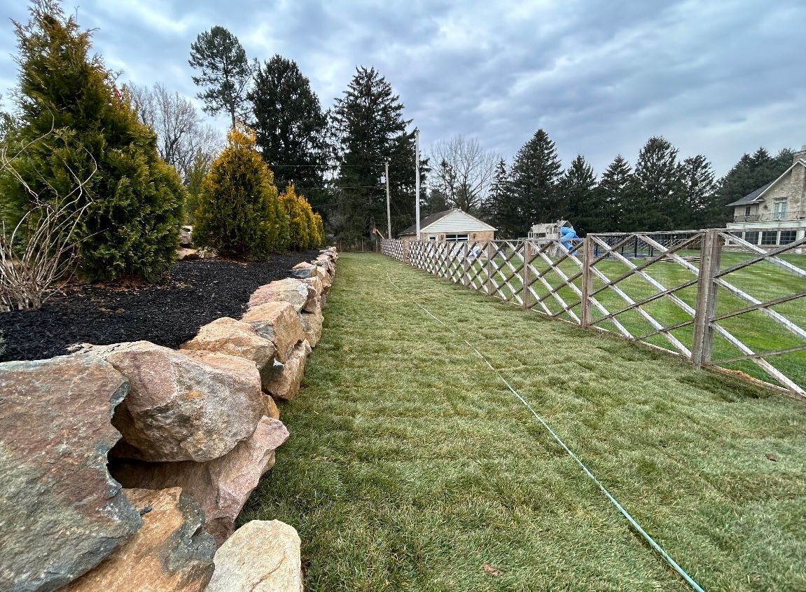 a wooden fence surrounds a lush green field