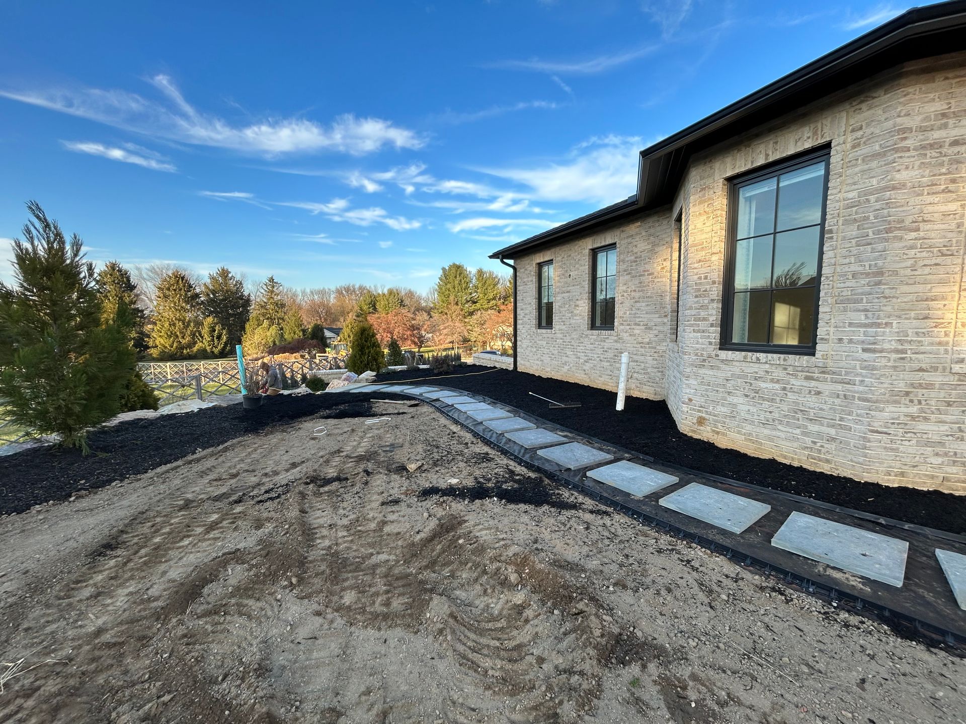 a large brick house with a walkway leading to it .