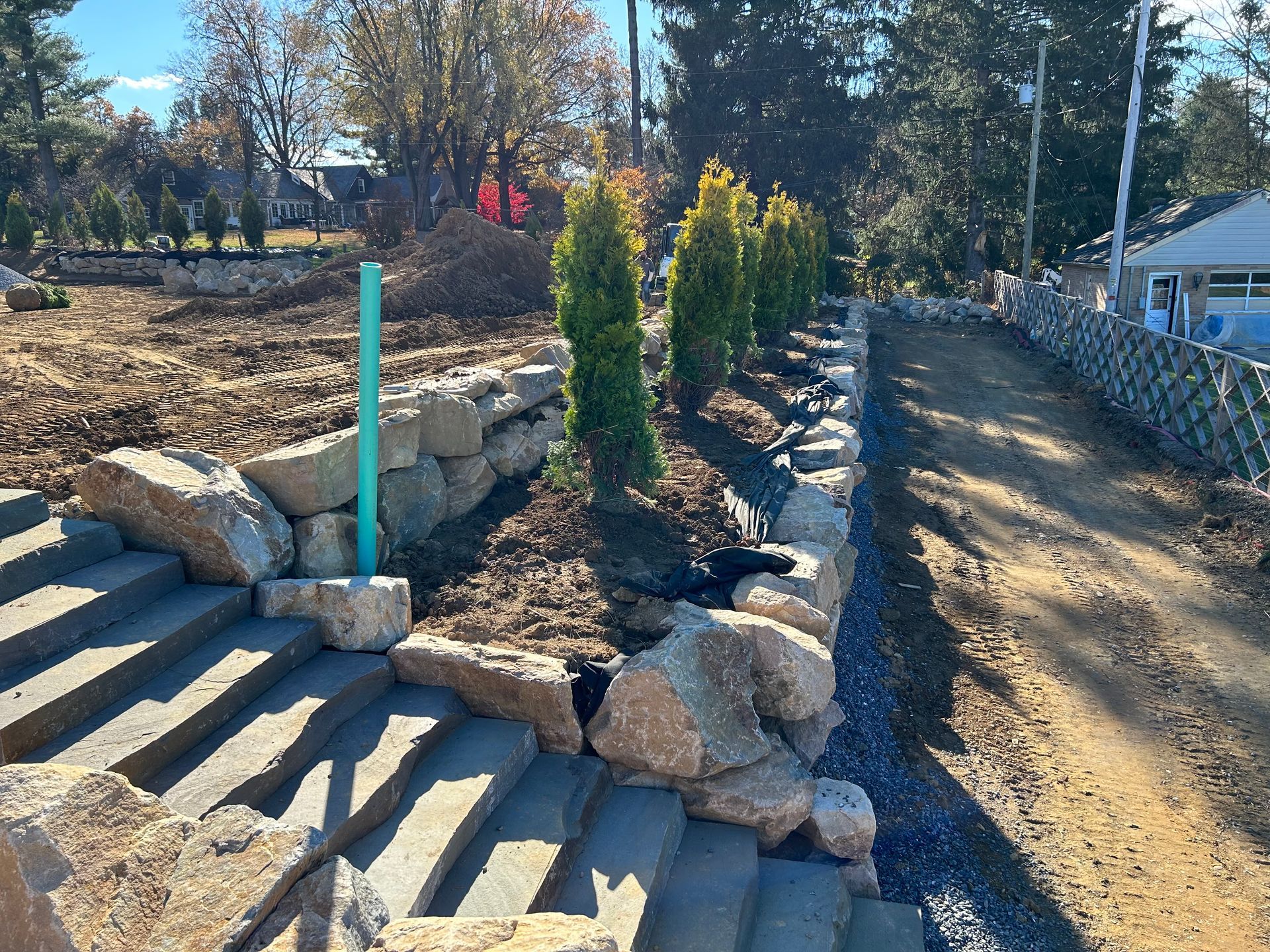 a dirt road going through a rocky area next to a house .