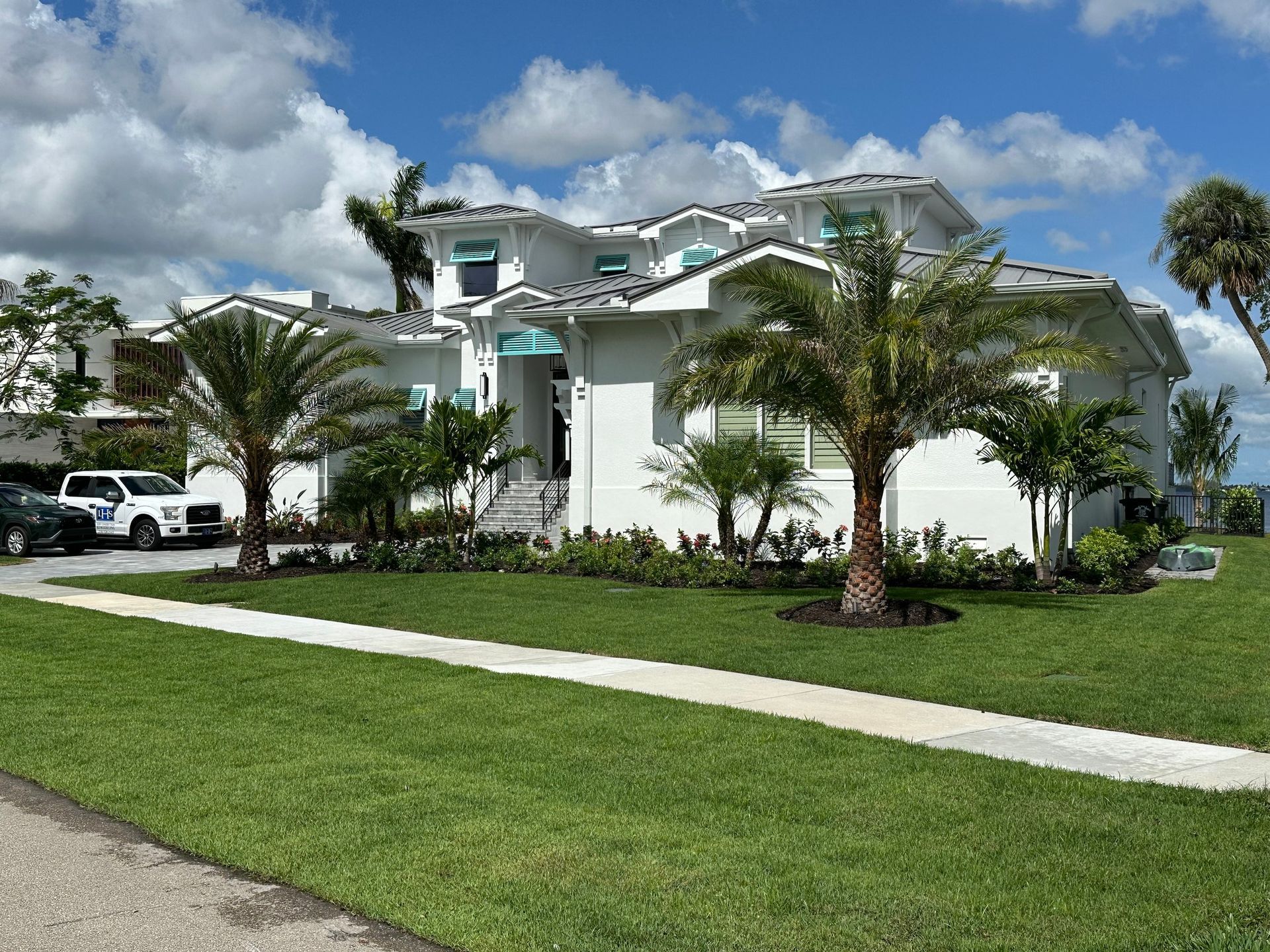 A large white house with palm trees in front of it.