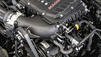 A close up of a car engine with a hose coming out of it.